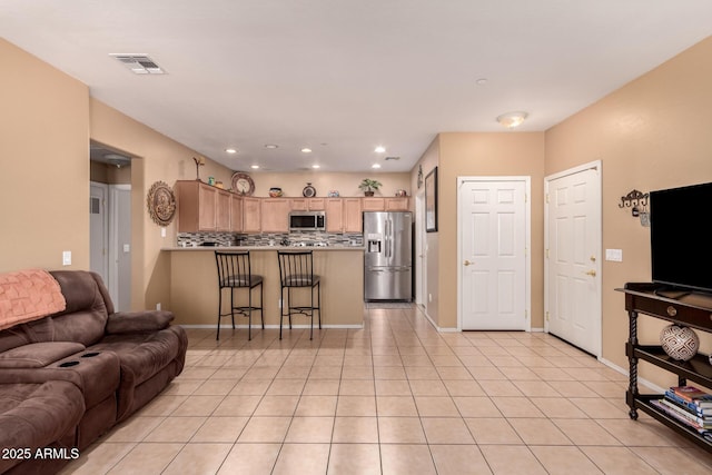 living room with light tile patterned floors, recessed lighting, visible vents, and baseboards