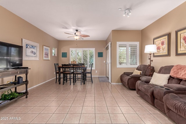 living room with light tile patterned floors, baseboards, and ceiling fan