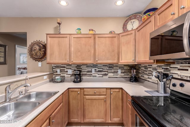 kitchen featuring tasteful backsplash, appliances with stainless steel finishes, light countertops, and a sink