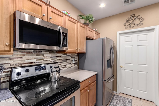 kitchen featuring tasteful backsplash, visible vents, light countertops, light tile patterned floors, and appliances with stainless steel finishes