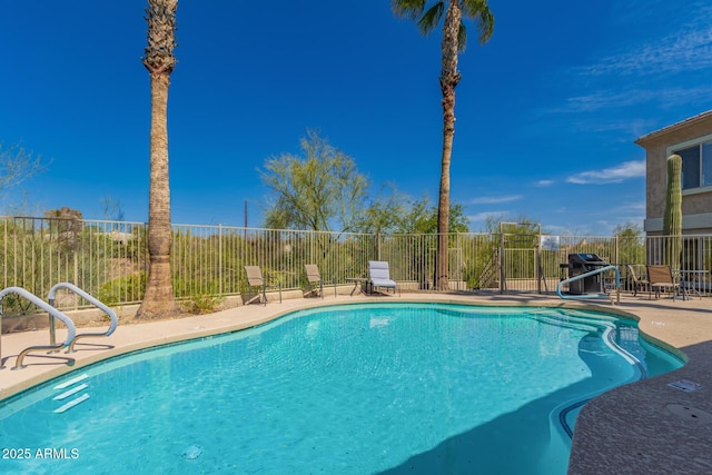 view of swimming pool with a patio area, grilling area, a fenced in pool, and fence