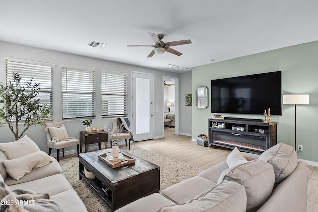 living room with ceiling fan and light hardwood / wood-style flooring