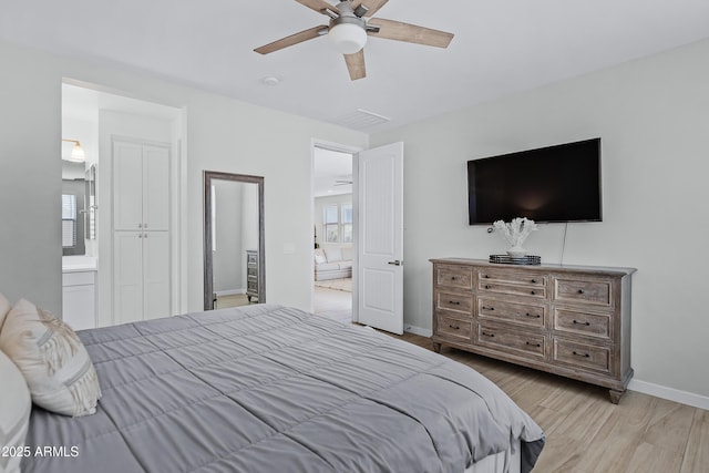 bedroom with connected bathroom, ceiling fan, and light hardwood / wood-style flooring