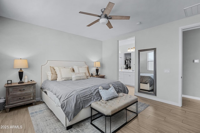 bedroom featuring connected bathroom, ceiling fan, and light hardwood / wood-style flooring