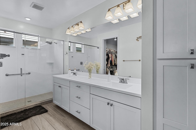 bathroom with vanity and a shower with door