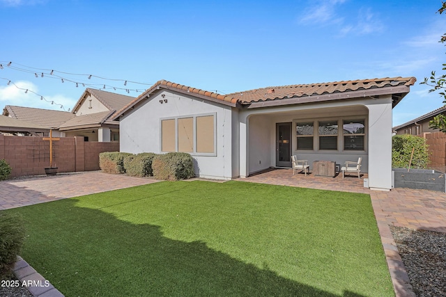 rear view of house featuring a patio area and a yard