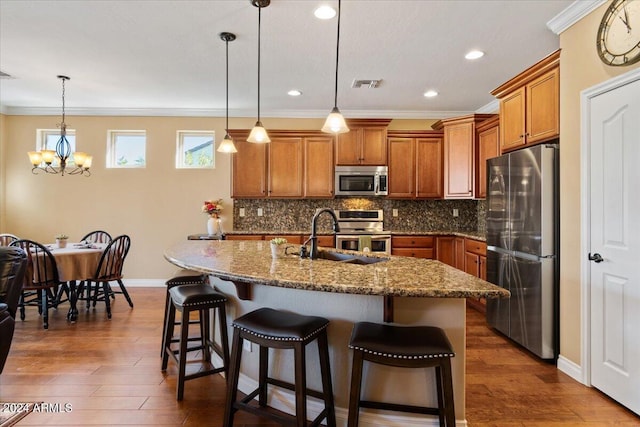 856 E Harmony Way, San Tan Valley, AZ 85140 - kitchen featuring stainless steel appliances, brown cabinetry, decorative backsplash, baseboards, and a kitchen breakfast bar
