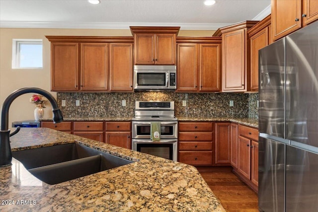 856 E Harmony Way, San Tan Valley, AZ 85140 - kitchen featuring stainless steel appliances, a sink, brown cabinets, crown molding, and recessed lighting