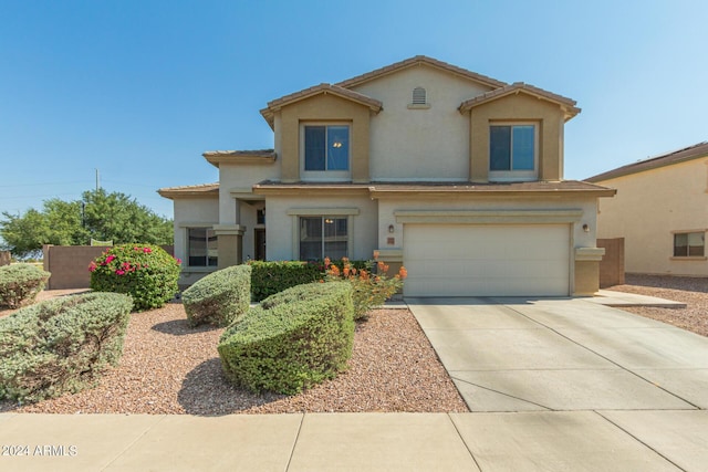 mediterranean / spanish home with an attached garage, concrete driveway, and stucco siding