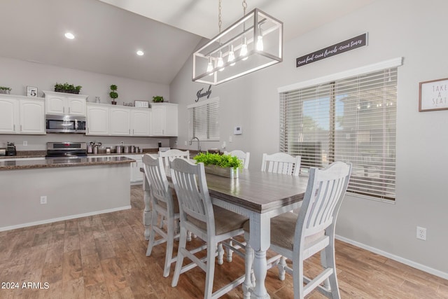 dining area with vaulted ceiling, recessed lighting, light wood-type flooring, and baseboards