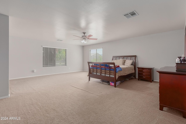 carpeted bedroom with baseboards, visible vents, and a ceiling fan