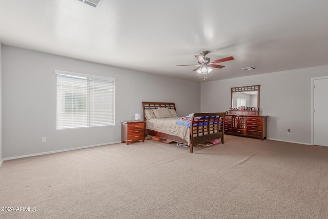 bedroom with light carpet, ceiling fan, visible vents, and baseboards