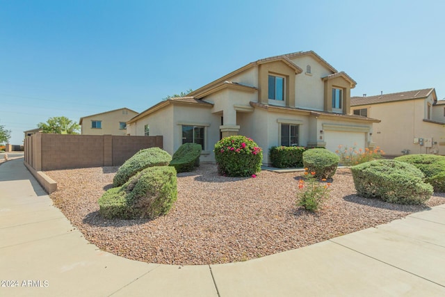 view of front facade featuring an attached garage, fence, and stucco siding