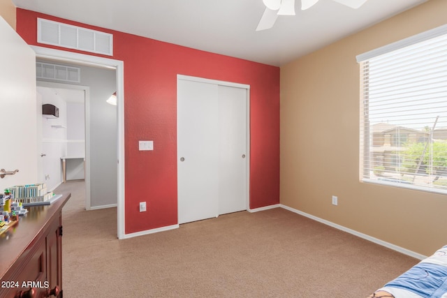 bedroom with baseboards, a closet, visible vents, and light colored carpet