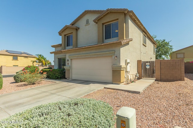 view of front of home with a garage, concrete driveway, a gate, fence, and stucco siding