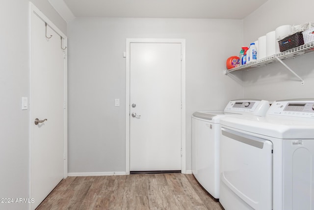 laundry room with light wood-type flooring, laundry area, baseboards, and washing machine and clothes dryer