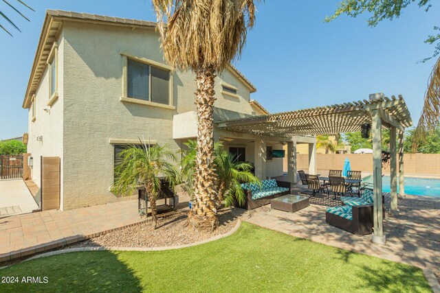 rear view of property featuring a patio, a pergola, an outdoor living space, and stucco siding