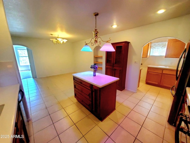 513 W Sherwood Dr, Payson, AZ 85541 - kitchen featuring light tile patterned floors, arched walkways, decorative light fixtures, light countertops, and a kitchen island