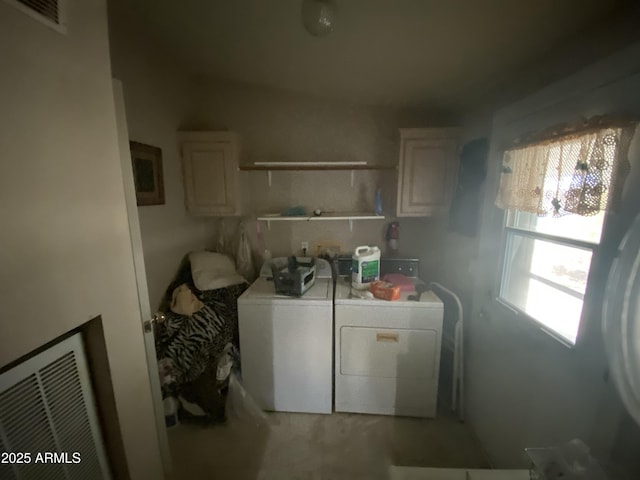 clothes washing area featuring washing machine and dryer and cabinets