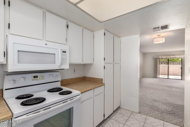 11026 N 28th Dr Unit 81, Phoenix, AZ 85029 - kitchen with white appliances, white cabinetry, light colored carpet, light countertops, and light tile patterned floors
