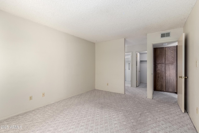 11026 N 28th Dr Unit 81, Phoenix, AZ 85029 - unfurnished bedroom with light carpet, a textured ceiling, a spacious closet, and a closet