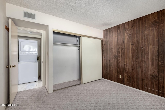 11026 N 28th Dr Unit 81, Phoenix, AZ 85029 - unfurnished bedroom with estacked washer and dryer, carpet, wood walls, a closet, and a textured ceiling