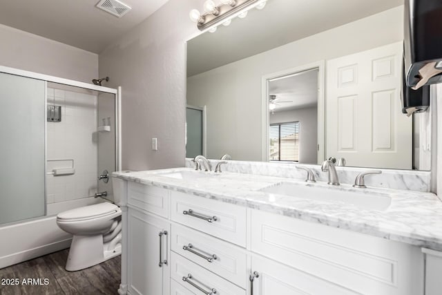 466 N 10th Pl, Coolidge, AZ 85128 - bathroom with double vanity, wood finished floors, bath / shower combo with glass door, and ceiling fan