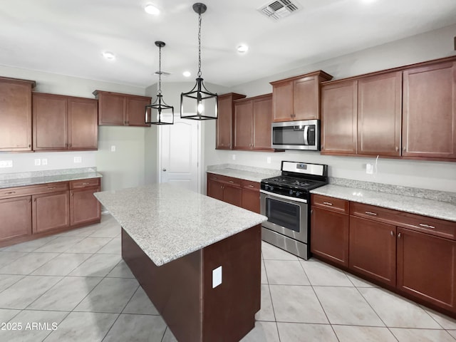 kitchen featuring pendant lighting, visible vents, appliances with stainless steel finishes, light tile patterned flooring, and a kitchen island