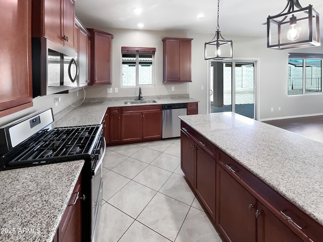 kitchen featuring hanging light fixtures, light stone countertops, stainless steel appliances, a sink, and light tile patterned flooring