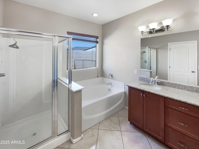 bathroom with a stall shower, a garden tub, vanity, and tile patterned floors