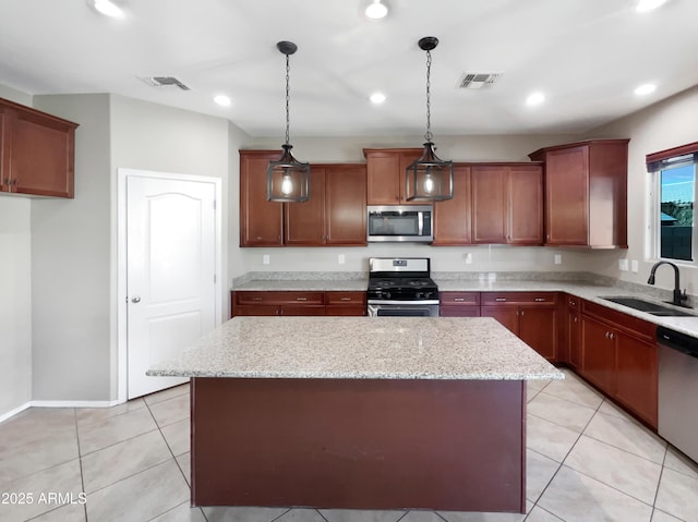 kitchen with a kitchen island, light stone counters, stainless steel appliances, and a sink