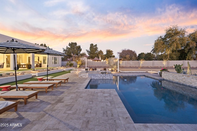 pool at dusk with a patio