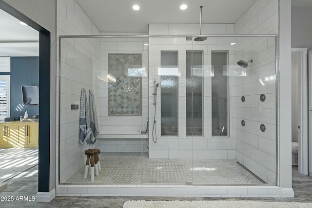 bathroom featuring a shower with shower door and toilet