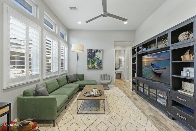 living room featuring ceiling fan and light hardwood / wood-style flooring