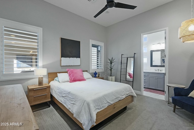 carpeted bedroom with ceiling fan, connected bathroom, and sink