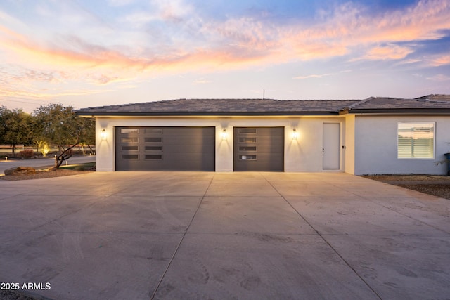 view of garage at dusk