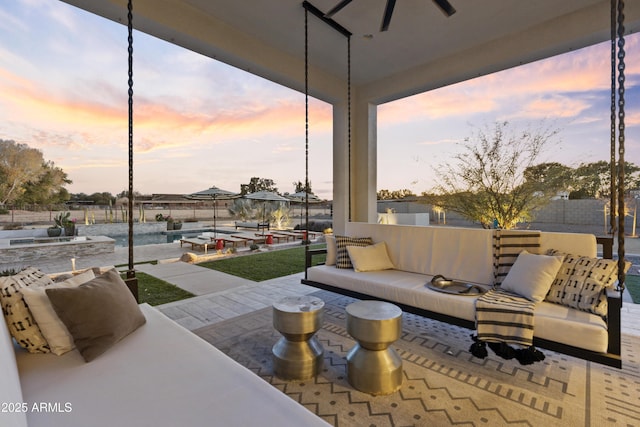 patio terrace at dusk with an outdoor living space and ceiling fan