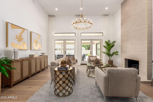 22756 N 91st Way, Scottsdale, AZ 85255 - living room featuring a chandelier, light wood-style floors, a high end fireplace, recessed lighting, and a towering ceiling