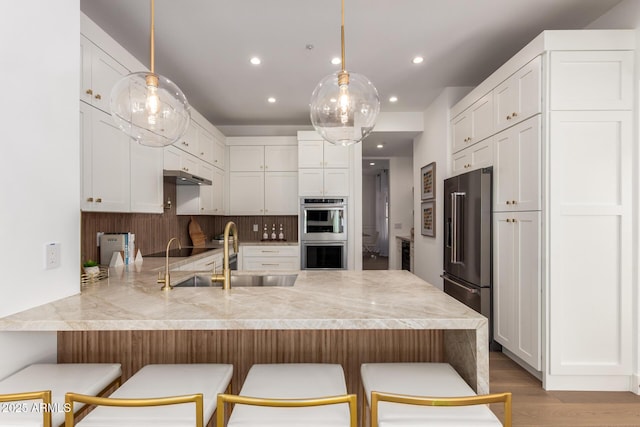 22756 N 91st Way, Scottsdale, AZ 85255 - kitchen featuring appliances with stainless steel finishes, a peninsula, light countertops, white cabinets, and light wood-style flooring