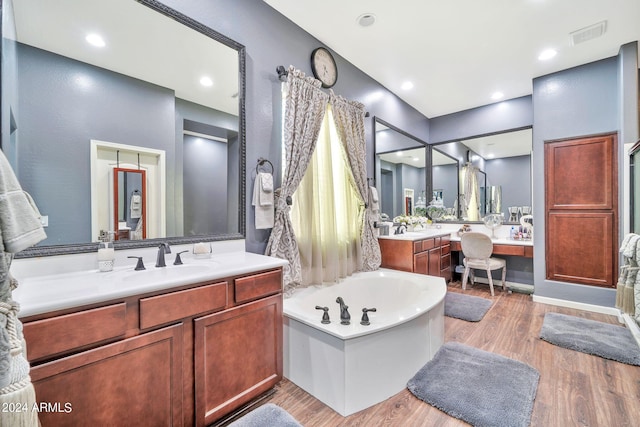 bathroom featuring hardwood / wood-style floors, vanity, and a washtub