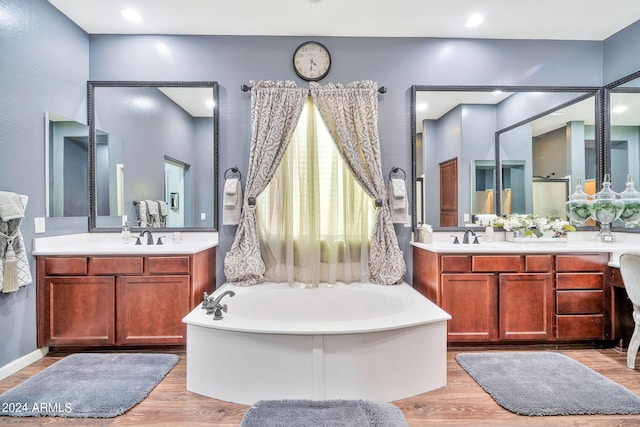 bathroom featuring wood-type flooring, a bathtub, and vanity