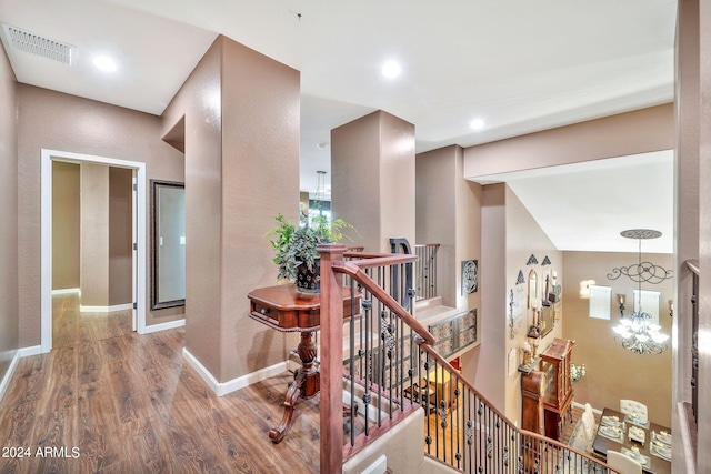 hall with hardwood / wood-style floors and a chandelier