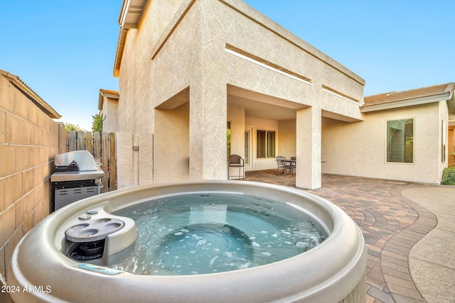 view of swimming pool with a grill, a hot tub, and a patio area