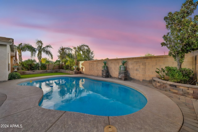 pool at dusk featuring a patio