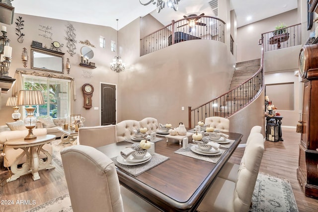 dining room featuring a towering ceiling, hardwood / wood-style floors, and ceiling fan