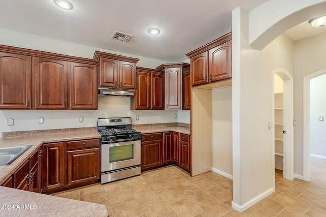 kitchen with sink, stainless steel range with gas cooktop, and a textured ceiling