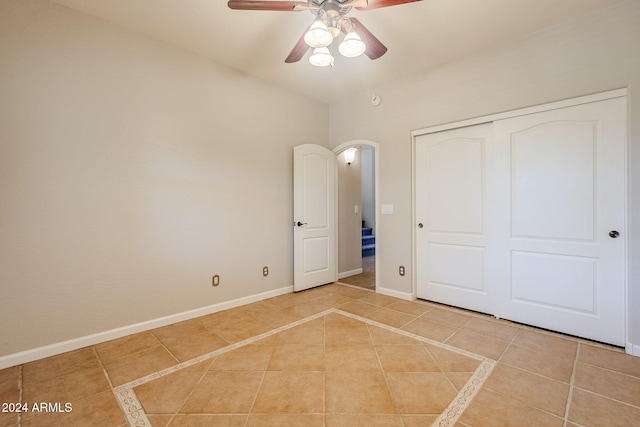 unfurnished bedroom featuring ceiling fan, light tile patterned floors, and a closet