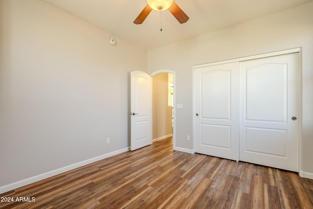 unfurnished bedroom featuring dark wood-type flooring, ceiling fan, and a closet