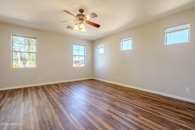 unfurnished room with plenty of natural light, ceiling fan, and dark hardwood / wood-style flooring