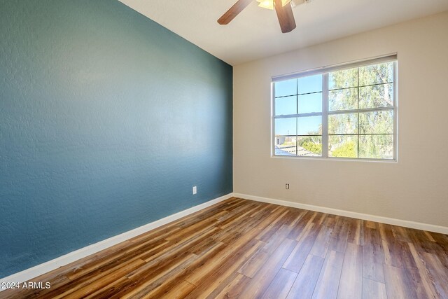 unfurnished room featuring hardwood / wood-style floors and ceiling fan